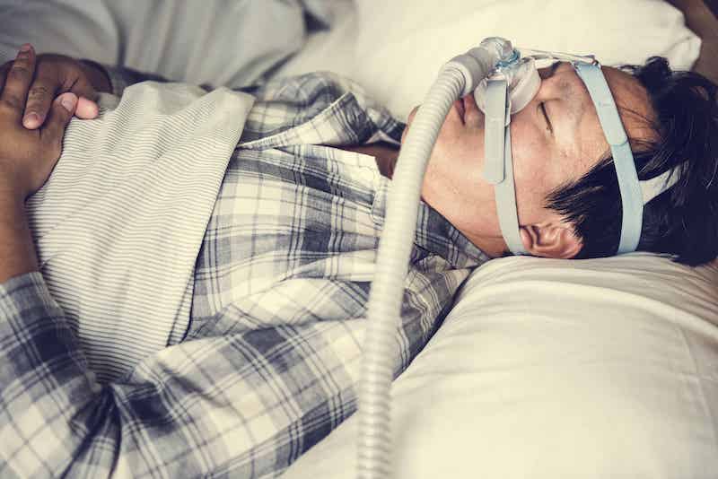 Man sleeping with CPAP device on